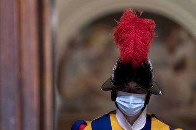 Un guardia suizo con mascarilla para prevenir el contagio del COVID-19 monta guardia en una puerta luego de una visita al Vaticano del secretario de Estado norteamericano Antony Blinken, el lunes 28 de junio de 2021, en Roma. (AP Foto/Andrew Harnik, Pool)