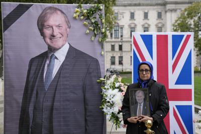 Miembros de la comunidad anglo-iraní y simpatizantes del Consejo Nacional de la Resistencia de Irán realizan una ceremonia en honor al legislador británico David Amess a las afueras de las Cámaras del Parlamento, el lunes 18 de octubre de 2021, en Londres. (AP Foto/Kirsty Wigglesworth)