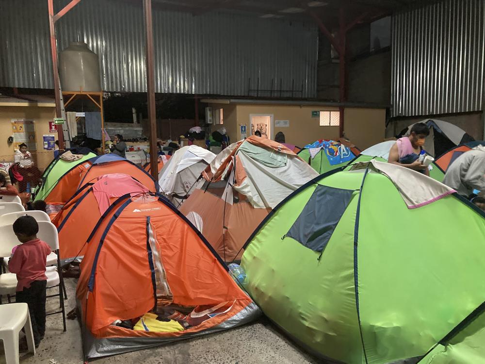 Migrantes, poco antes de que se apaguen las luces en el albergue Juventud 2000, en Tijuana, México, el 13 de octubre de 2022. El nuevo plan de EEUU que amplía las restricciones de asilo a los venezolanos supone un reto añadido para la ya desbordada red de albergues en México, que apenas puede hacer frente a la creciente llegada de extranjeros. Washington aceptará hasta 24.000 migrantes venezolanos que cumplan una serie de requisitos y devolverá a México a quienes entren de forma ilegal. (AP Foto/Elliot Spagat)