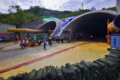 Rescatistas levantan barreras para bombear el agua de un túnel inundado en la ciudad de Zhuhai, en la provincia de Guangdong, en el sur de China, el 16 de julio de 2021. (Chinatopix via AP)