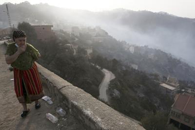 Fotografía del miércoles 11 de agosto de 2021 de una mujer en la aldea Larbaa Nath Irathen, cerca de Tizi Ouzou, a 100 kilómetros (60 millas) al este de Argelia tras los incendios que han matado al menos a 69 personas en la región montañosa bereber. (AP Foto/Fateh Guidoum)