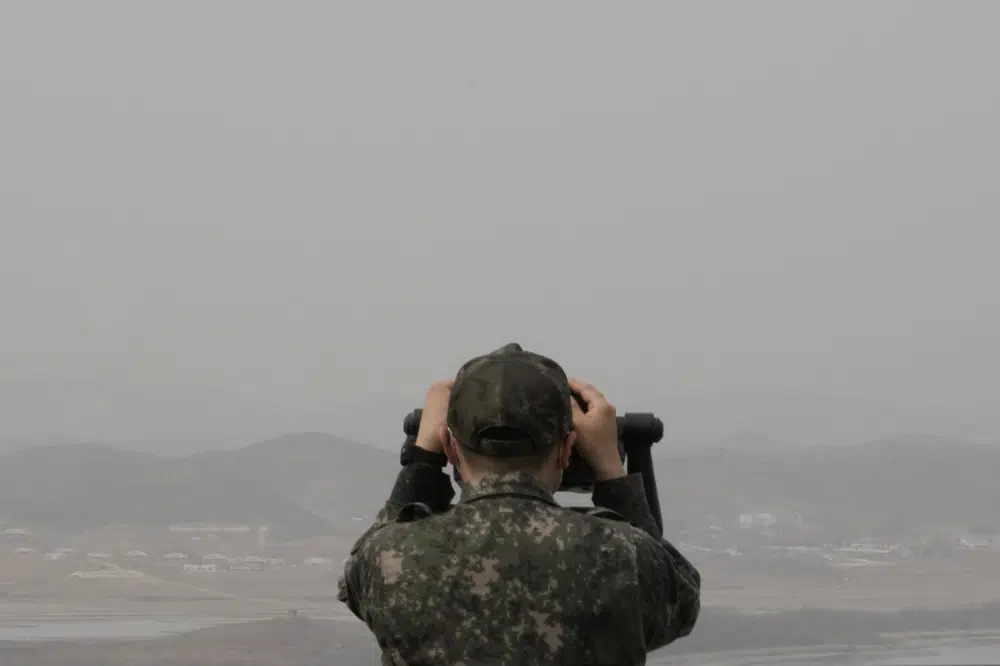 Un soldado del ejército de Corea del Sur observa al lado de Corea del Norte desde el Puesto de Observación de Unificación en Paju, Corea del Sur, cerca de la frontera con Corea del Norte, el viernes 24 de marzo de 2023. Corea del Norte dijo el viernes que sus lanzamientos de misiles de crucero esta semana fueron parte de un ataque nuclear. simulaciones que también involucraron la detonación de un supuesto dron submarino cuando el líder Kim Jong Un prometió hacer que sus rivales "se hundieran en la desesperación".  (Foto AP/Ahn Young-joon)