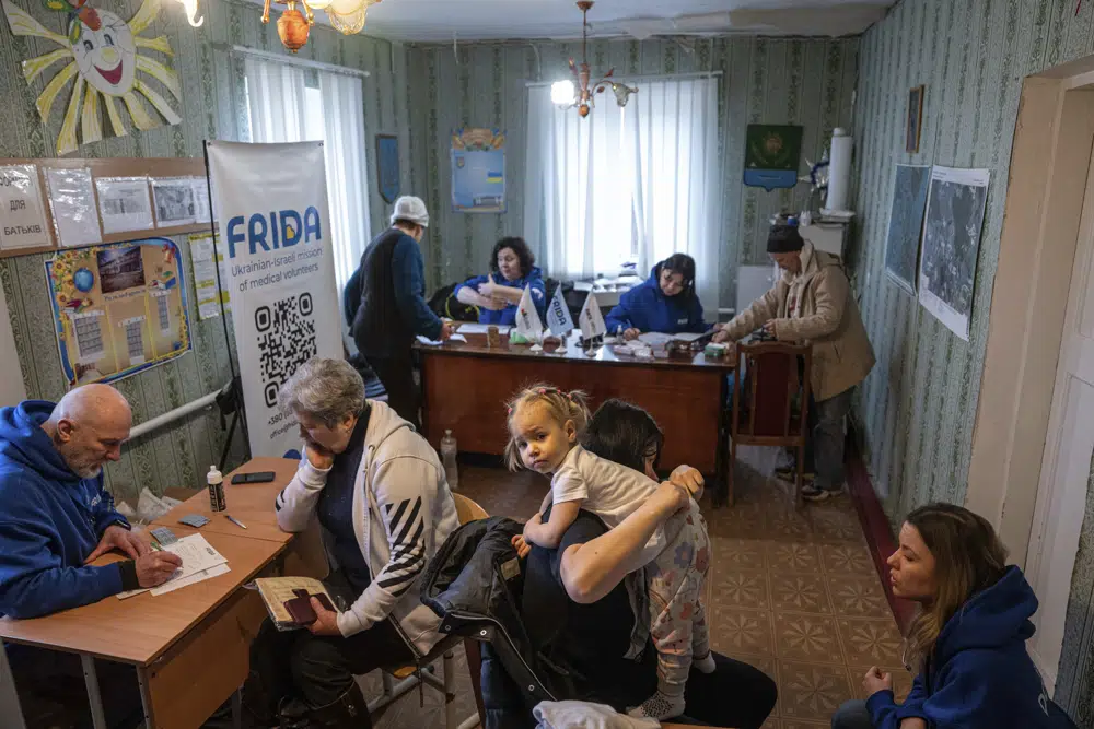 Trabajadores voluntarios de FRIDA Ukraine atienden a pacientes mientras prestan atención médica especializada a civiles en el pueblo de Khrestysche, en la región de Donetsk, Ucrania, el domingo 19 de marzo de 2023. (AP Foto/Evgeniy Maloletka)