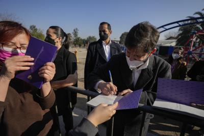 El presidente de Chile, Gabriel Boric, firma un borrador de la Constitución propuesta luego de asistir a un evento para animar a la gente a votar en el próximo plebiscito en Santiago, Chile, el jueves 21 de julio de 2022. (Foto AP/Esteban Félix)