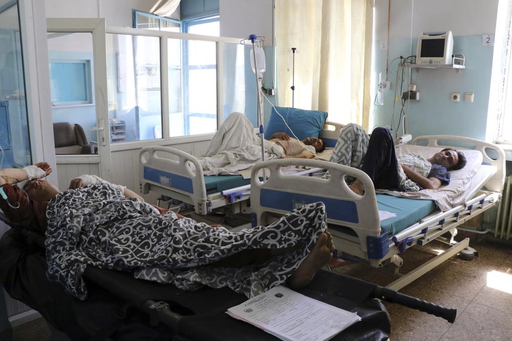 Afghans lie on beds at a hospital after they were wounded in the deadly attacks outside the airport in Kabul, Afghanistan, Friday, Aug. 27, 2021. Two suicide bombers and gunmen attacked crowds of Afghans flocking to Kabul's airport Thursday, transforming a scene of desperation into one of horror in the waning days of an airlift for those fleeing the Taliban takeover. (AP Photo/Wali Sabawoon)