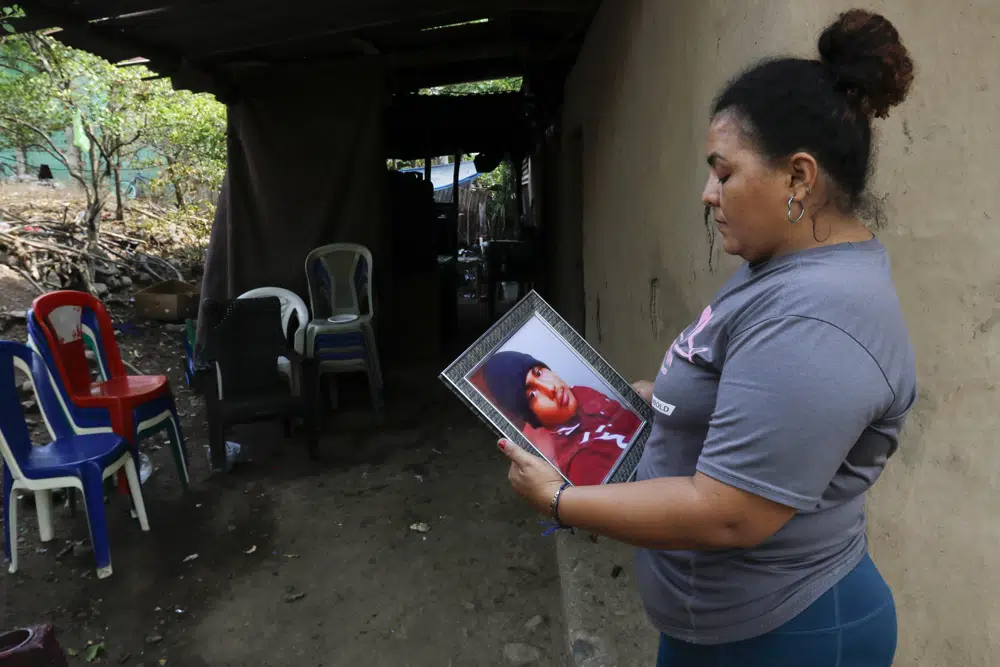 Norma Espinoza sostiene un retrato de su hijo Angel Maradiaga, en su casa en Olanchito, Honduras, el sábado 13 de mayo de 2023. Maradiaga, de 17 años, quien fue detenido en un centro en Safety Harbor, Florida, murió el miércoles.  Epinoza exige respuestas de los funcionarios estadounidenses, diciendo que su hijo no tenía enfermedades conocidas y que no había mostrado signos de estar enfermo antes de su muerte.  (Foto AP/Delmer Martínez)