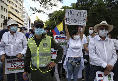 Una mujer sostiene un letrero durante una marcha en silencio para pedir que se retiren los bloqueos en las avenidas de la ciudad de Cali, Colombia, el martes 25 de mayo de 2021. (AP Foto/Andrés González)