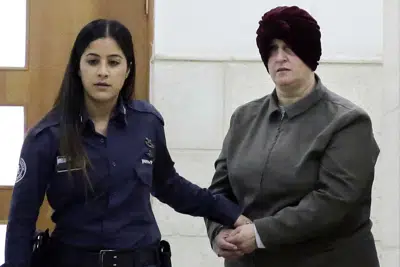 ARCHIVO - La australiana nacida en Israel Malka Leifer, a la derecha, es conducida a la sala del tribunal en Jerusalén el 27 de febrero de 2018. Leifer, exdirectora de una escuela femenina judía, fue condenada por abusar sexualmente de dos alumnas. (AP Foto/Mahmoud Illean, Archivo)