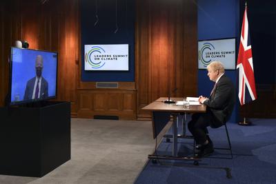 ARCHIVO - En esta foto de archivo del 22 de abril de 2021, el primer ministro británico Boris Johnson escucha al presidente estadounidense Joe Biden, en la pantalla, durante la Cumbre Climática virtual. (Justin Tallis/Pool Foto via AP, File)