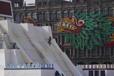 Operarios construyen una réplica del Templo Mayor azteca, con una imagen del dios precolombino Quetzalcoatl adornando los edificios colindantes, en la Plaza del Zócalo, en Ciudad de México, el 9 de agosto de 2021. La ciudad se está preparando para el 500 aniversario de la caída de la capital azteca, Tenochtitlan, hoy Ciudad de México, el 13 de agosto de 2021. (AP Foto/Eduardo Verdugo)