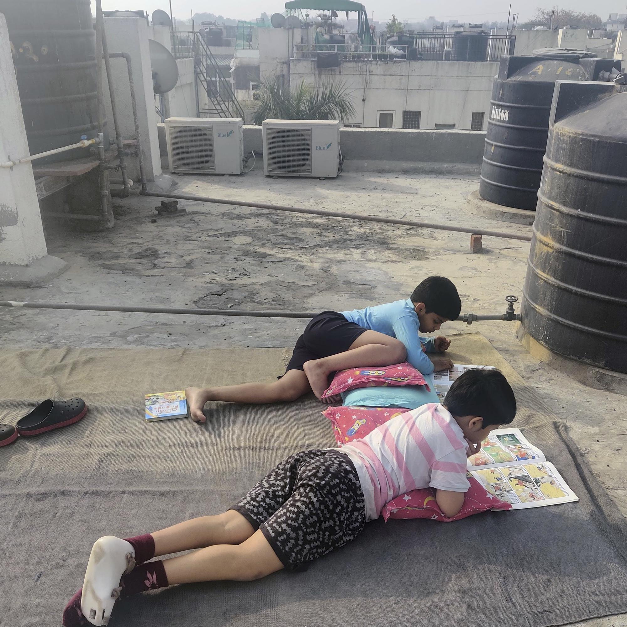 This 2021 photo provided by Aparna Vaidik shows her sons, Advait Vallabh Sanweria 10, foreground, and Uddhav Pratap Sanweria 9, on the terrace of their apartment in New Delhi. The boys talk about their hope for free vaccines, even if they are too young to get them themselves. Indian Prime Minister Narendra Modi has since announced a plan to distribute free shots, in a bid to fully vaccinate the country by end of the year. (Aparna Vaidik via AP)