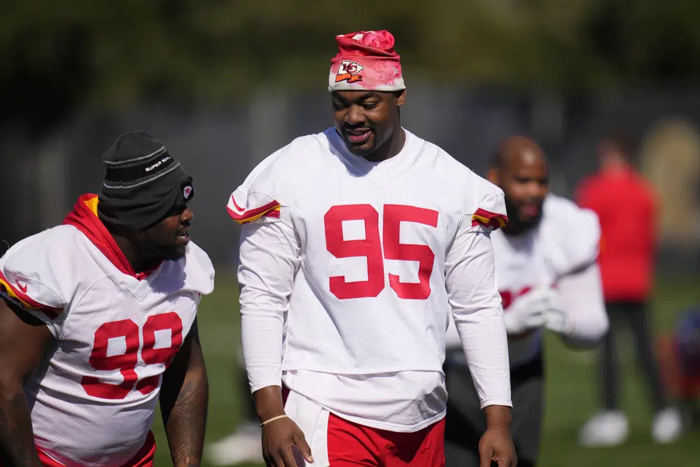 Kansas City Chiefs defensive tackles Chris Jones (95) and Khalen Saunders (99) talk as players warm up during an NFL football practice in Tempe, Ariz., Wednesday, Feb. 8, 2023. The Chiefs will play against the Philadelphia Eagles in Super Bowl LVII on Sunday. (AP Photo/Ross D. Franklin)