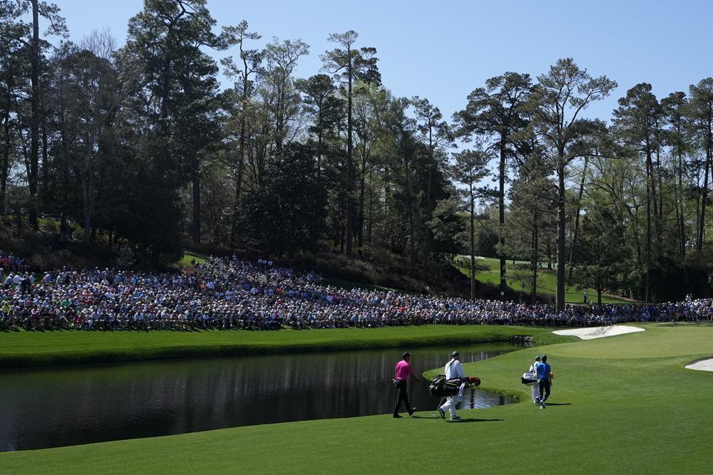 Tiger Woods, a la izquierda, camina con Joaquín Niemann, de Chile, en la calle 16 durante la primera ronda del torneo de golf Masters el jueves 7 de abril de 2022 en Augusta, Georgia (Foto AP/David J. Phillip)
