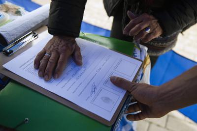 Una persona firma y estampa su huella digital en una petición de referéndum en Montevideo, Uruguay, el miércoles 7 de julio de 2021. Este miércoles es el último día para que los ciudadanos firmen una petición pidiendo un referéndum que busca revocar una ley aprobada por el gobierno de Luis Lacalle Pou que flexibiliza las condiciones de subida de precios de combustibles, desalojos y otros rubros. (AP Foto/Matilde Campodonico)