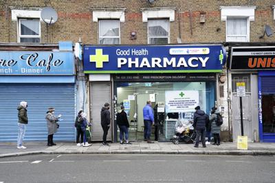 Personas hacen fila para ponerse la vacuna contra el coronavirus en Londres el 25 de diciembre del 2021.  (Gareth Fuller/PA via AP)