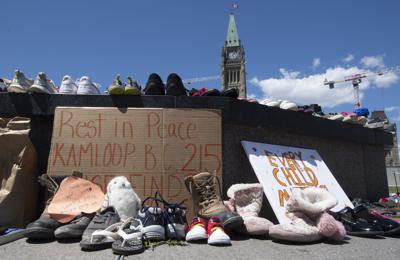 ARCHIVO - Esta foto de archivo del 31 de mayo de 2021 muestra zapatos en un monumento improvisado tras el hallazgo de restos de niños en el lugar donde se encontraba un internado para niños indígenas, en Kamloops, Columbia Británica, Canadá. (Adrian Wyld/The Canadian Press vía AP, archivo)