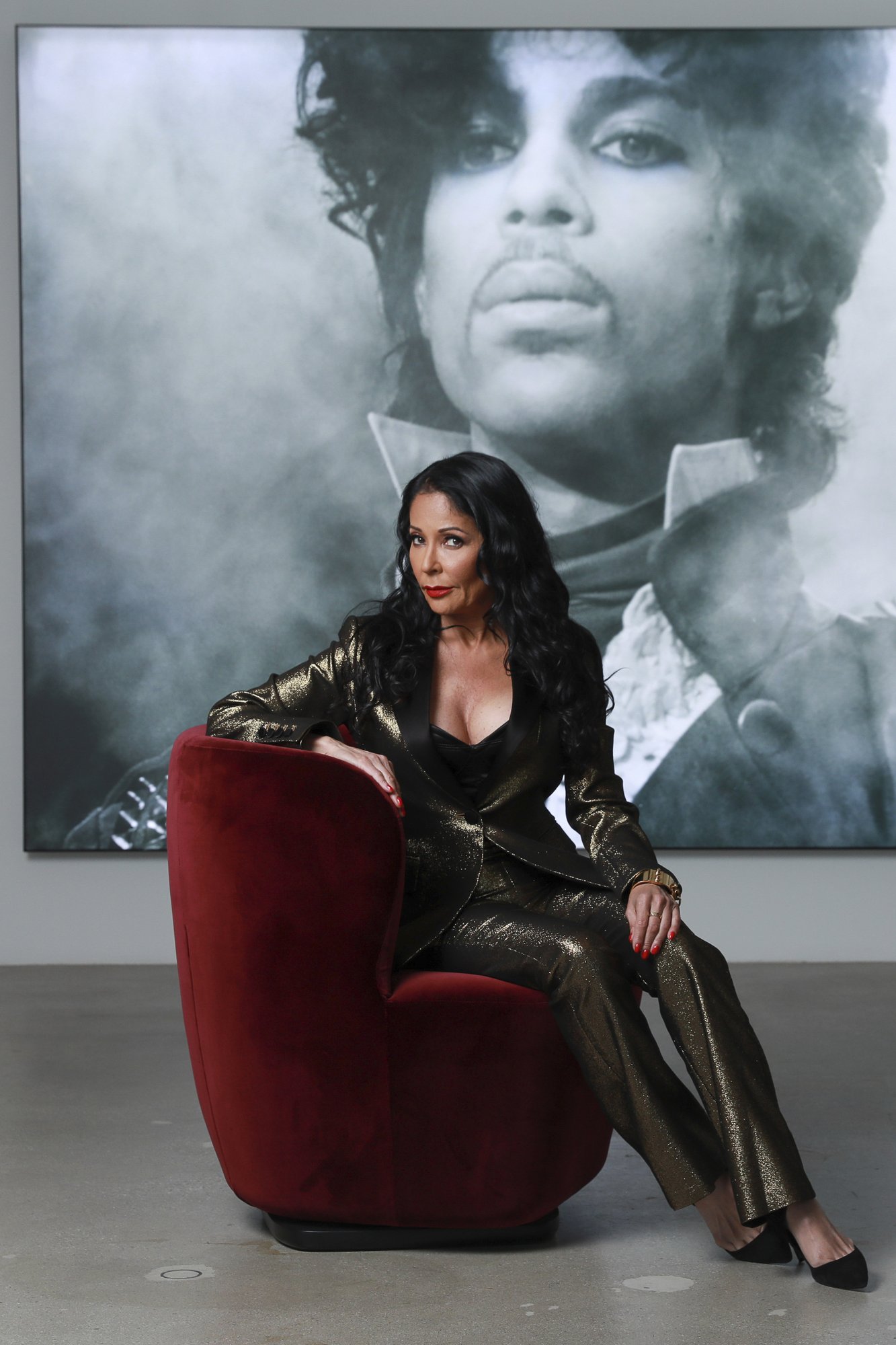 Apollonia Kotero poses for a portrait in front of a photo of Prince at Warner Music Group in Los Angeles on Friday, May 31, 2019. Kotero, who recorded Prince's