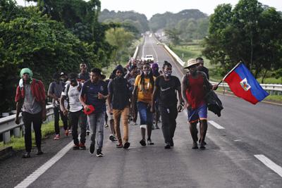 Migrantes haitianos caminan por la carretera en Huixtla, estado de Chiapas, México, la madrugada del jueves 2 de septiembre de 2021, en su viaje hacia Estados Unidos. (AP Foto/Marco Ugarte)