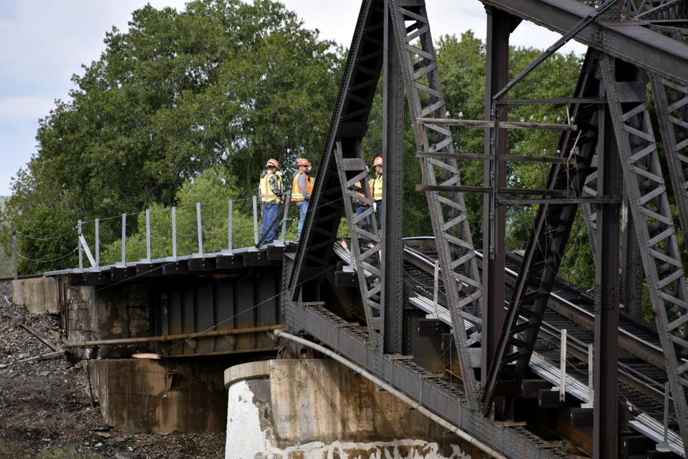 Emergency crews respond to the scene where several train cars are immersed in the Yellowstone River after a bridge collapse near Columbus, Mont., on Saturday, June 24, 2023. The bridge collapsed overnight, causing a train that was traveling over it to plunge into the water below. (AP Photo/Matthew Brown)