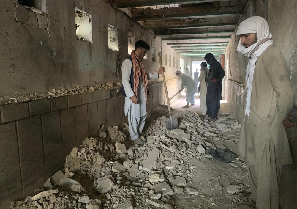 Люди осматривают внутреннюю часть мечети после нападения террористов-смертников в городе Кандагар, на юго-западе Афганистана, в пятницу, 15 октября 2021 года. Террористы-смертники атаковали шиитскую мечеть на юге Афганистана, которая была заполнена верующими, посещающими пятничную молитву, в результате чего погибло несколько человек. и ранили других, по словам сотрудника больницы и свидетеля. (AP Photo / Sidiqullah Khan)