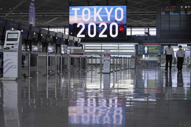 Personal, con mascarilla para protegerse del coronavirus, pasean por una zona de embarque vacía en el aeropuerto internacional de Narita, el 1 de junio de 2021, en Narita, al este de Tokio. (AP Foto/Eugene Hoshiko)