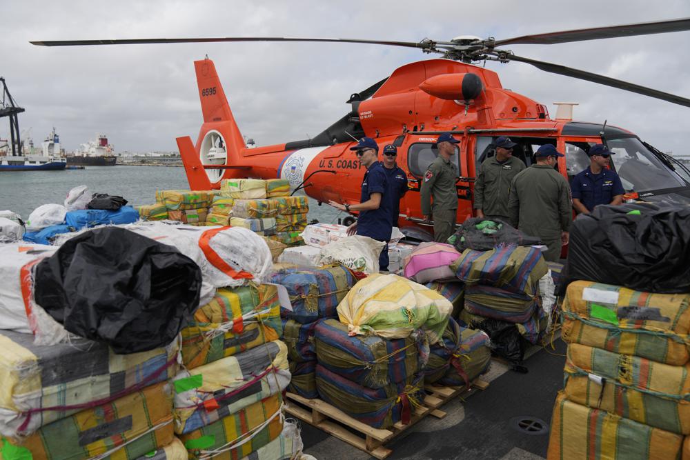 Miembros de la Guardia Costera de EE. UU. junto a paquetes de cocaína y marihuana incautados por un valor de más de mil millones de dólares, a bordo del guardacostas James en Port Everglades, el jueves 17 de febrero de 2022, en Fort Lauderdale, Florida. incluyó aproximadamente 54,500 libras de cocaína y 15,800 libras de marihuana de múltiples interdicciones en el Mar Caribe y el Pacífico oriental. (Foto AP/Rebecca Blackwell)
