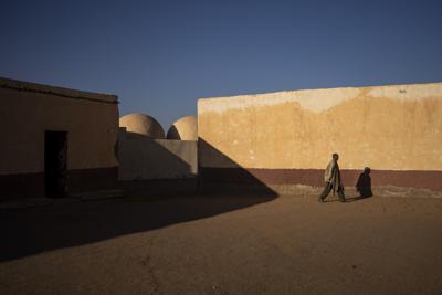 ARCHIVO - Un hombre camina por el patio de una escuela cerrada el miércoles 13 de octubre de 2021, en Bir Lahlou, Sahara Occidental. (AP Foto/Bernat Armangue, archivo)