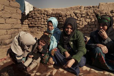 Aziz Gul, segunda desde la derecha, y su hija de 10 años, Qandi, al centro, pemanecen fuera de su casa con otros miembros de la familia cerca de Herat, en Afganistán, el 16 de diciembre de 2021. (AP Foto/Mstyslav Chernov)