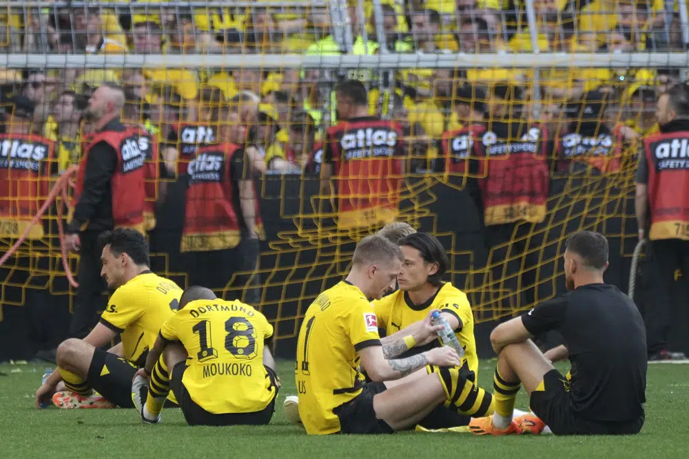 Dortmund's players sit on the pitch after the German Bundesliga soccer match between Borussia Dortmund and FSV Mainz 05 in Dortmund, Germany, Saturday, May 27, 2023. (AP Photo/Michael Probst)