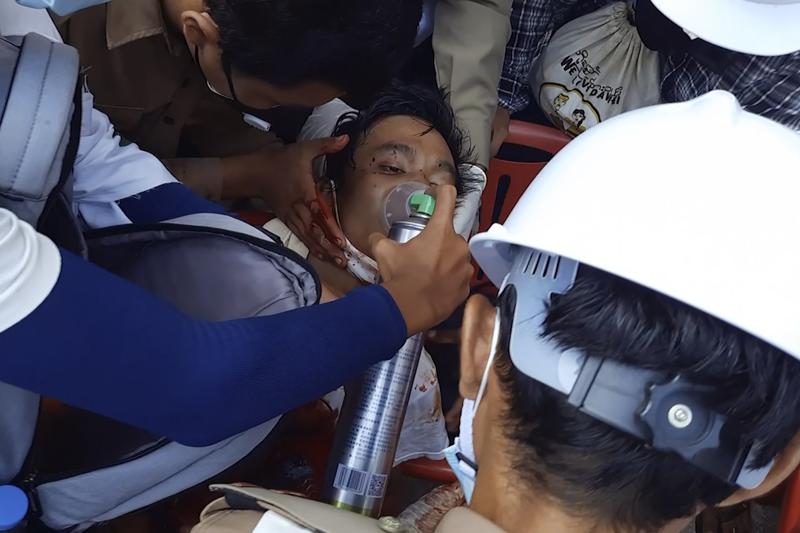 FILE - In this Sunday, Feb. 28, 2021 image from video provided by Dakkhina Insight, medics attend to a man who appeared to be wounded in his upper chest on a street in Dawei, Myanmar. In Myanmar, the military has declared war on health care _ and on doctors themselves, who were early and fierce opponents of the takeover in February. (Dakkhina Insight via AP)