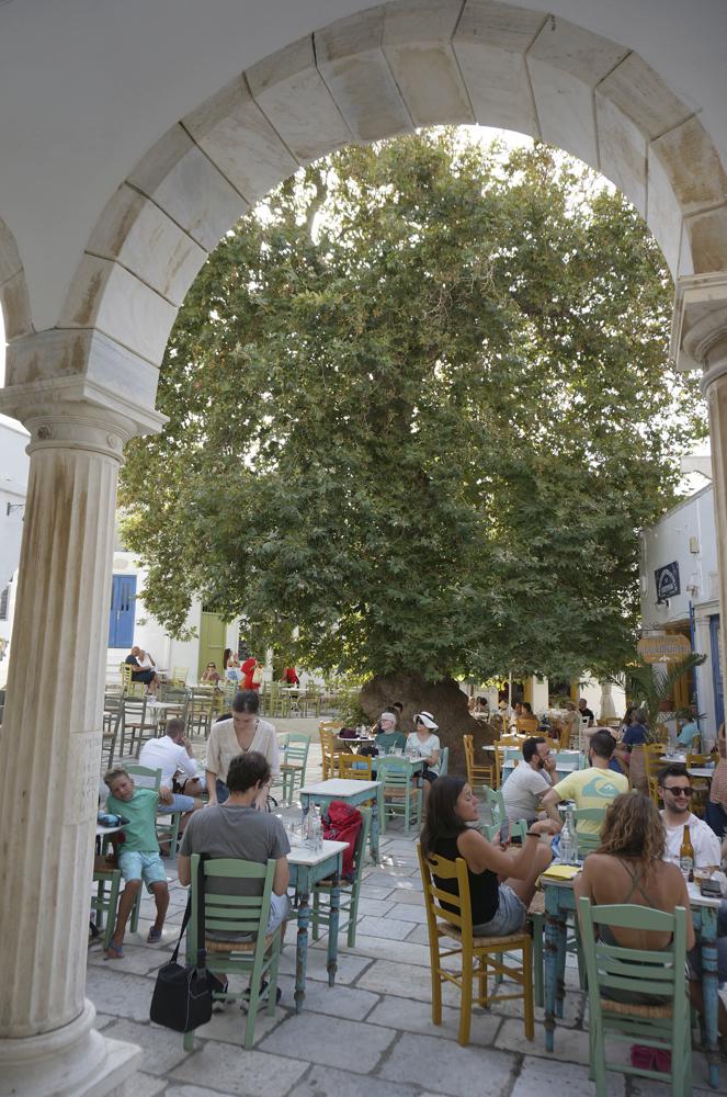 Ένας μεγάλος πλάτανος σκιάζει τη γεμάτη καφετέριες, μαρμαρόστρωτη κεντρική πλατεία στο χωριό Πύργος στην Τήνο, Ελλάδα, στις 26 Αυγούστου 2021. Τα τηνιακά χωριά είναι πλούσια διακοσμημένα με μάρμαρο από τοπικά λατομεία και ο Πύργος στεγάζει τη μαρμαροτεχνία μουσείο καθώς και πολλά εργαστήρια καλλιτεχνών. (AP Photo/Giovanna Dell'Orto)