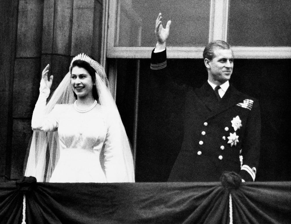 FILE - In this Nov. 20, 1947 file photo, Britain's Princess Elizabeth and her husband the Duke of Edinburgh wave to the crowds on their wedding day, from the balcony of Buckingham Palace in London.  Queen Elizabeth II, Britain’s longest-reigning monarch and a rock of stability across much of a turbulent century, has died. She was 96. Buckingham Palace made the announcement in a statement on Thursday Sept. 8, 2022.(AP Photo/File)