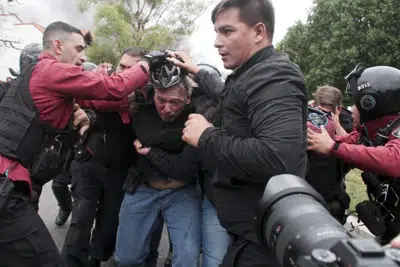 Sergio Berni, el ministro de Seguridad de la provincia de Buenos Aires, en el centro, es extraído de una protesta en Buenos Aires, el lunes 3 de abril de 2023. Berni fue atacado durante una protesta de conductores de autobuses luego del asesinato de un compañero de trabajo. (AP Foto/Andrés Pelozo)