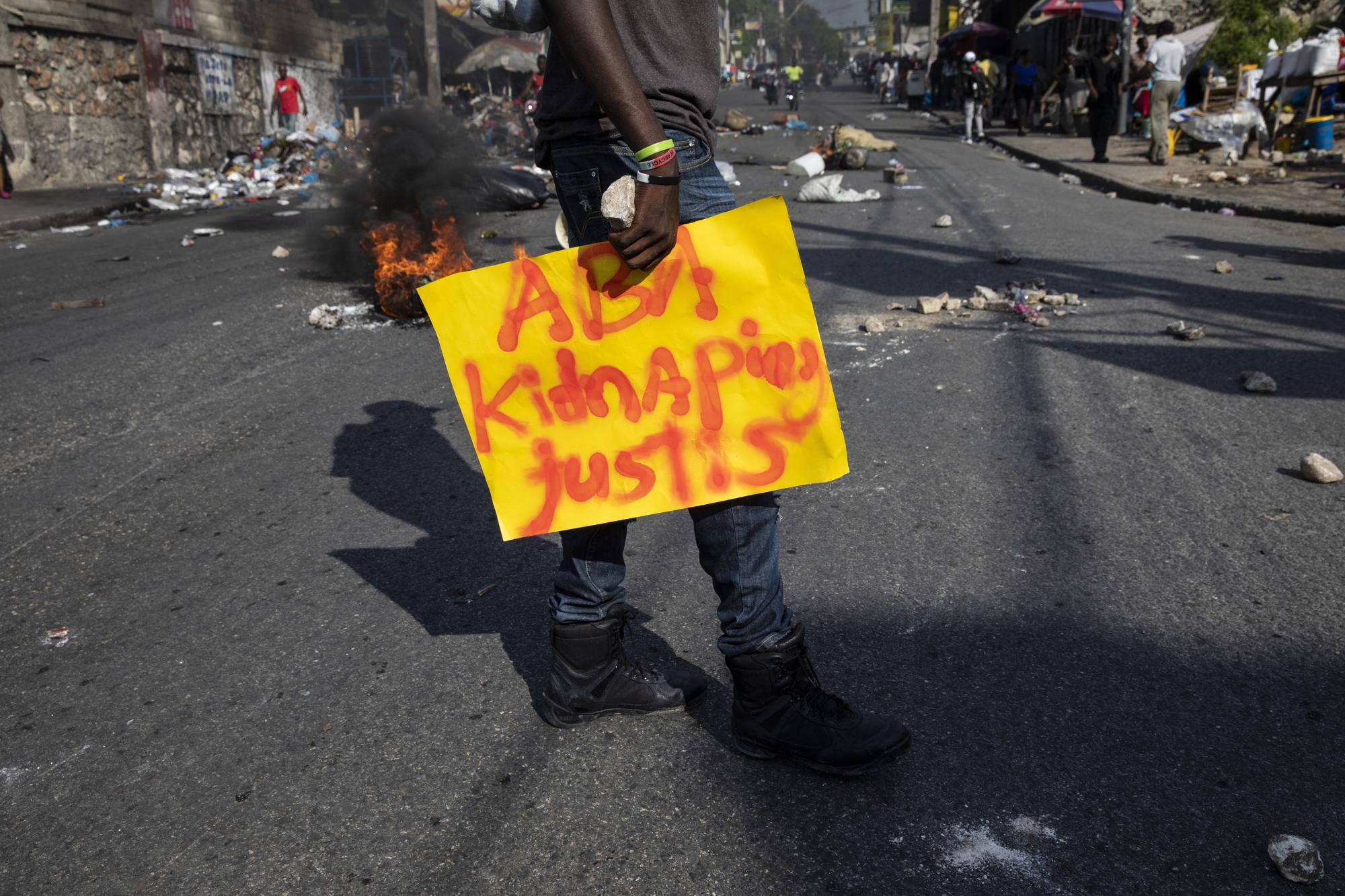 A man carries a banner that reads in Creole: "Stop kidnapping. Justice," during a protest organized by friends and relatives of Biana Velizaire who was kidnapped and held for several days by gang members, in Port-au-Prince, Haiti, Monday, Sept. 27, 2021. At least 328 kidnappings were reported to Haiti's National Police in the first eight months of 2021, compared with a total of 234 for all of 2020, according to a report issued last month by the U.N. Integrated Office in Haiti. (AP Photo/Rodrigo Abd)