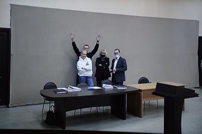 En esta imagen proveída por el Servicio  Penal Federal de Rusia, el líder opositor Alexei Navalny saluda a los periodistas y partidarios vía video en una sesion de la corte, acompañado por su esposa Yulia y sus abogadios, en Pokrov, 100 kilómetros (62 millas) al este de Moscú, el 17 de enero del 2022. (AP Foto/Denis Kaminev)