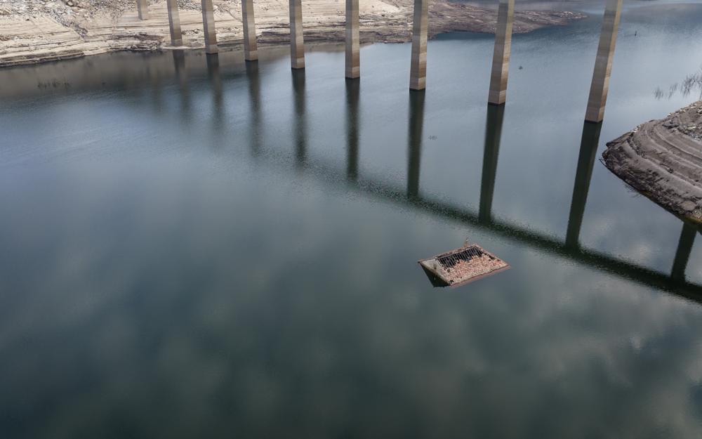 El tejado de una vieja casa sumergida hace tres décadas cuando una presa hidroeléctrica inundó el valle, emerge debido a la sequía en el embalse de Lindoso, en el noroeste de España, el sábado 12 de febrero de 2022. Gran parte de España sufre una sequía extrema o prolongada, tras un invierno en el que ha llovido apenas un tercio de la media de los últimos años. (AP Foto/Emilio Morenatti)