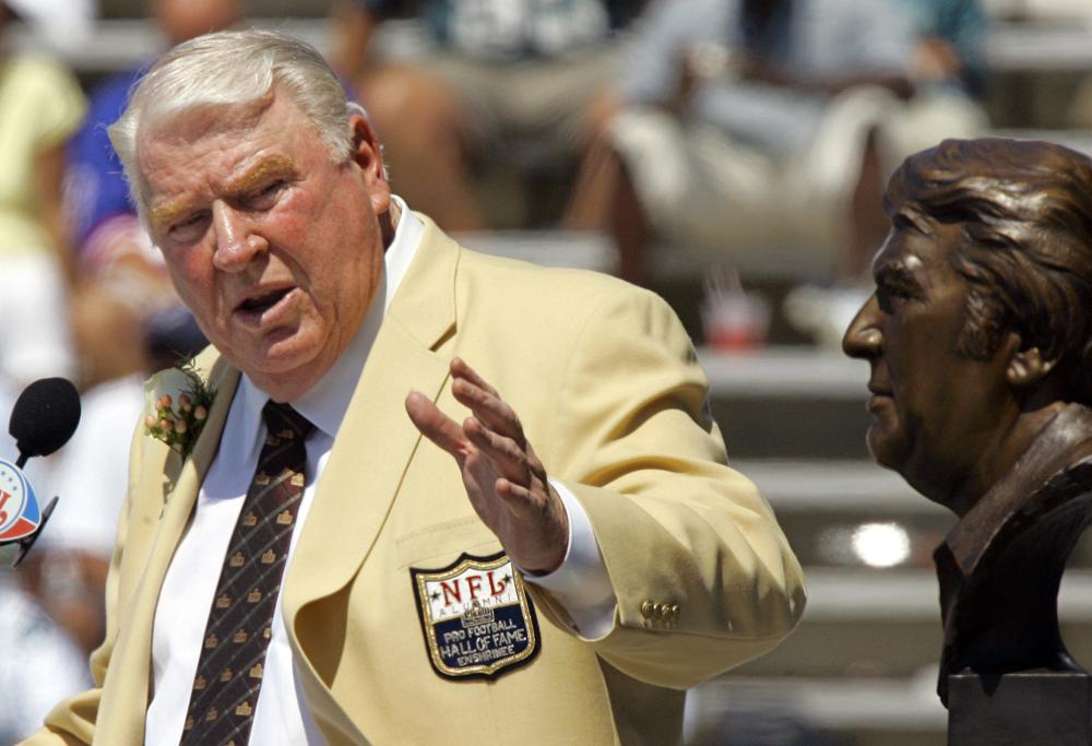 FILE - Former Oakland Raiders coach John Madden gestures toward a bust of himself during his enshrinement into the Pro Football Hall of Fame in Canton, Ohio, Aug. 5, 2006. John Madden, the Hall of Fame coach turned broadcaster whose exuberant calls combined with simple explanations provided a weekly soundtrack to NFL games for three decades, died Tuesday, Dec. 28, 2021, the NFL said. He was 85. (AP Photo/Mark Duncan, File)