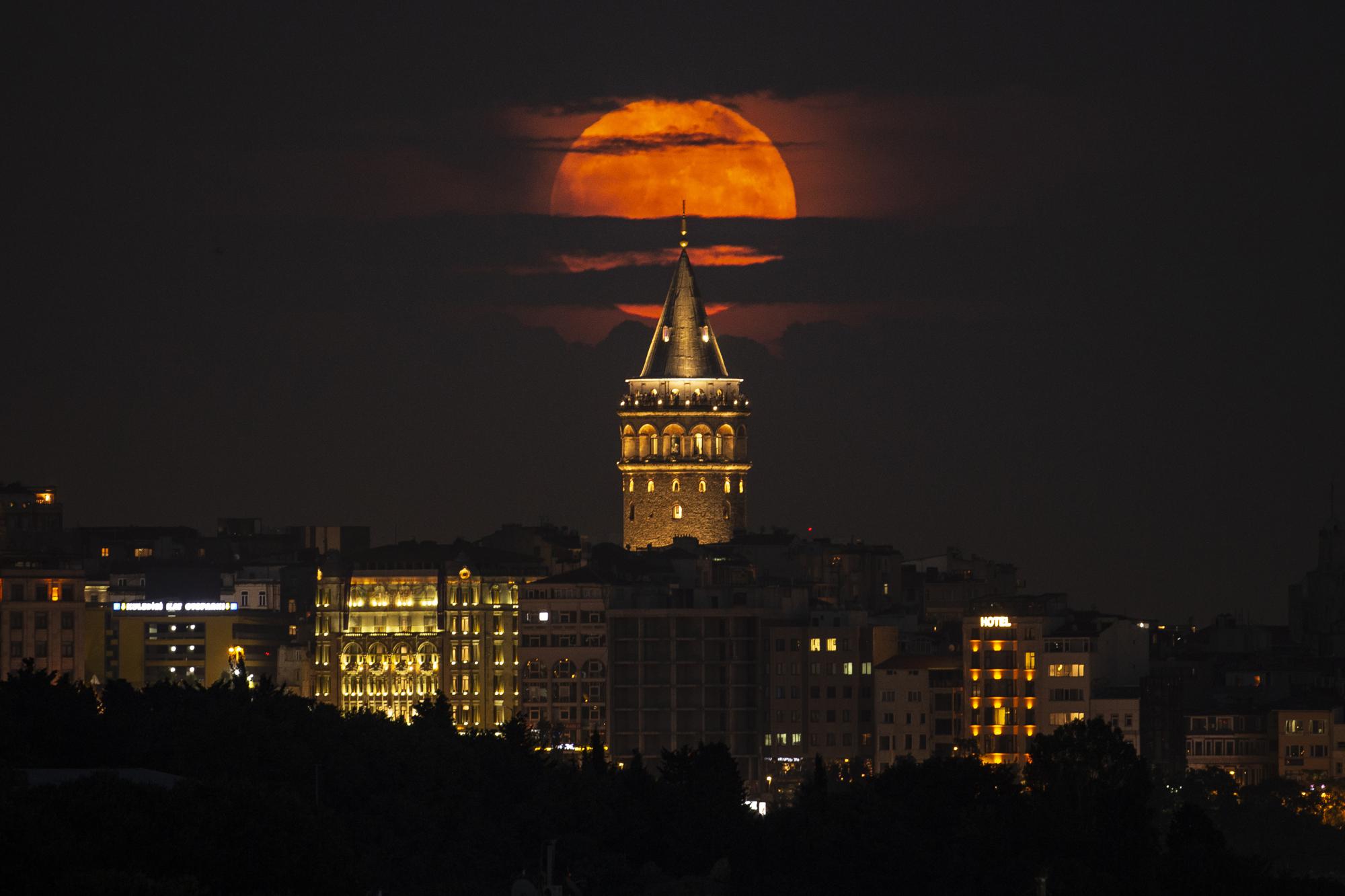 Uma superlua surge atrás da Torre Galata em Istambul, Turquia, terça-feira, 14 de junho de 2022. A lua atingiu seu estágio completo na terça-feira, durante um fenômeno conhecido como superlua por causa de sua proximidade com a Terra, e também é rotulado como o " Strawberry Moon" porque é lua cheia na época da colheita do morango. (Foto AP/Emrah Gurel)