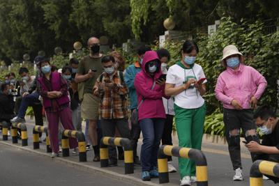 Pobladores con mascarillas hacen fila para hacerse pruebas de COVID-19 en el distrito de Chaoyang, el lunes 25 de abril de 2022 en Beijing. (AP Foto/Ng Han Guan)