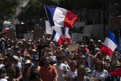 Manifestantes marchan por Marsella, Francia, sábado 14 de agosto de 2021, contra el pasaporte COVID-19, una certificación obligatoria para entrar a restaurantes, trenes de alta velocidad y otros recintos. (AP Foto/Daniel Cole)