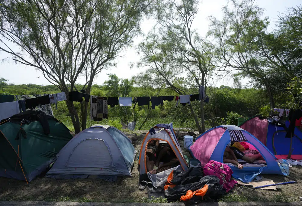 Migrantes venezolanos descansan dentro de sus tiendas de campaña a orillas del Río Grande en Matamoros, México, el domingo 14 de mayo de 2023. A medida que EE. cruces (Foto AP/Fernando Llano)