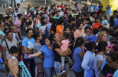 Fotografía de archivo del 20 de agosto de 2019 de migrantes regresados a México bajo el programa del gobierno de Donald Trump "Permanecer en México" formados para recibir una comida en un campamento cerca de puente internacional Gateway en Matamoros, México. (AP Foto/Veronica G. Cardenas, Archivo)