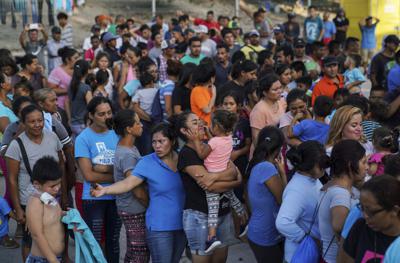 Fotografía de archivo del 20 de agosto de 2019 de migrantes regresados a México bajo el programa del gobierno de Donald Trump "Permanecer en México" formados para recibir una comida en un campamento cerca de puente internacional Gateway en Matamoros, México. (AP Foto/Veronica G. Cardenas, Archivo)