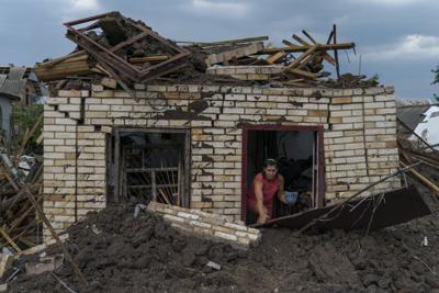 Olga Rudneva, residente de la localidad ucraniana de Druzhkivka, recupera un artículo para un anciano dueño de una casa dañada el jueves 18 de agosto de 2022 luego de un lanzamiento de cohetes rusos en la región de Donetsk, en el este de Ucrania. (AP Foto/David Goldman)