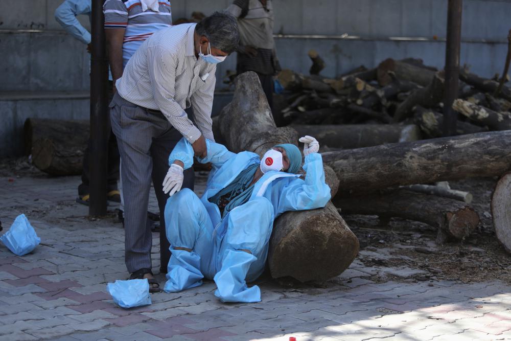 FILE - In this April 25, 2021, file photo, a relative of a person who died of COVID-19 breaks down during cremation in Jammu, India. Indias excess deaths during the pandemic could be a staggering 10 times the official COVID-19 toll, likely making it modern Indias worst human tragedy, according to the most comprehensive research yet on the ravages of the virus in the south Asian country. (AP Photo/Channi Anand, File)