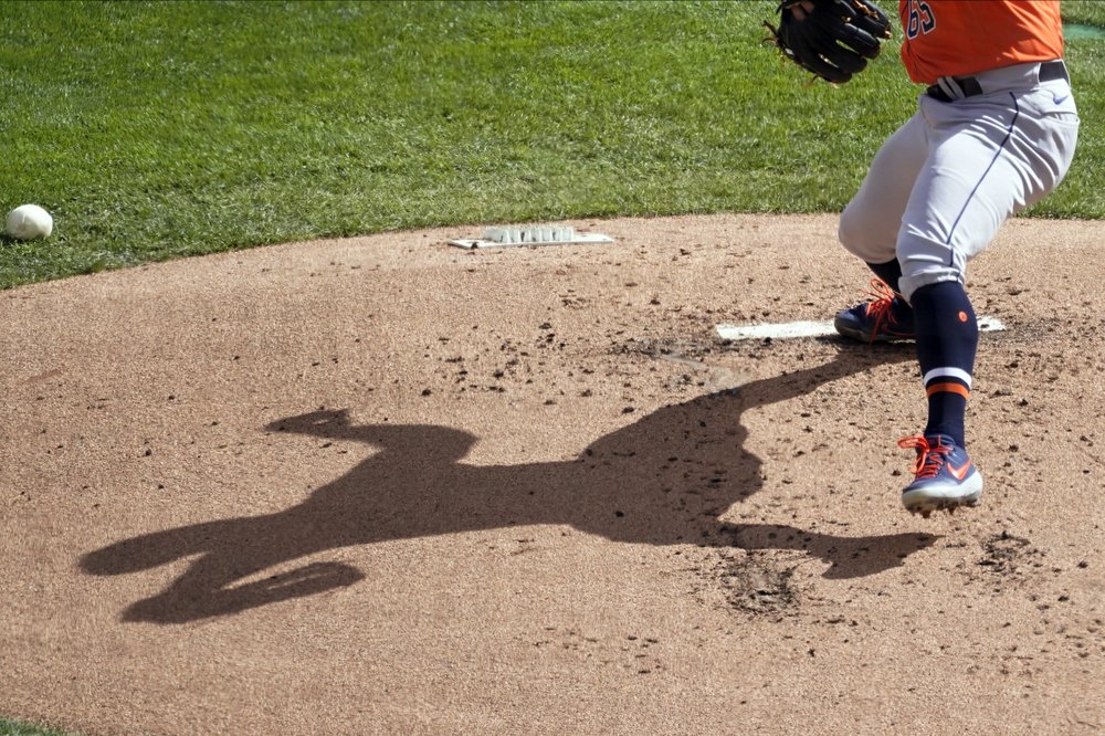 La sombra del lanzador de los Houston Astros, José Urquidy, se muestra en el montículo mientras lanza contra los Mellizos de Minnesota en la primera entrada de un juego de béisbol de la serie de comodines de la Liga Americana, el miércoles 30 de septiembre de 2020.