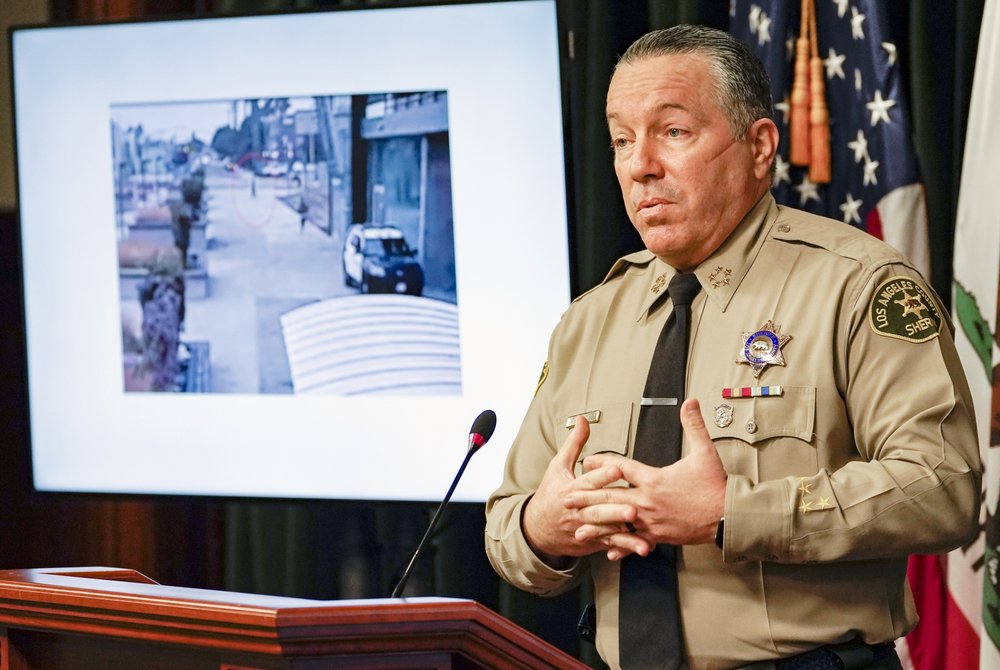 FILE - In this Sept. 17, 2020 file photo, Los Angeles County Sheriff Alex Villanueva comments on the investigation of the shooting of two deputies during a news conference at the Hall of Justice in downtown Los Angeles. A photo from surveillance video of the assault is at left. Authorities say they have arrested a man in connection with the shooting of two Los Angeles County sheriff's deputies as they sat in their squad car. Villanueva and District Attorney Jackie Lacey on Wednesday, Sept. 30, 2020 said attempted murder charges have been filed against 36-year-old Deonte Lee Murray. He was arrested two weeks ago in connection with a separate carjacking. (AP Photo/Damian Dovarganes, File)