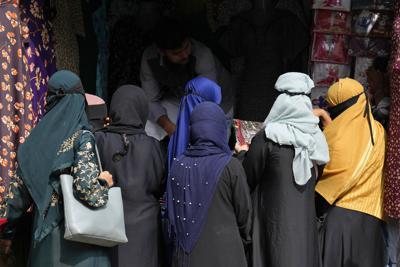 Un grupo de mujeres usan el pañuelo musulmán mientras compran ropa en Bangalore, India, el jueves 13 de octubre de 2022. (AP Foto/Aijaz Rahi)