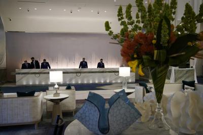 ARCHIVO - En esta imagen de archivo del 23 de junio de 2021, gente trabajando en la recepción del hotel Crockfords en Resorts World Las Vegas, en Las Vegas. La mayoría de las personas vacunadas no necesitan tomar precauciones especiales en los hoteles, pero la actitud que le resulte más cómoda puede depender de sus circunstancias. (AP Foto/John Locher, Archivo)