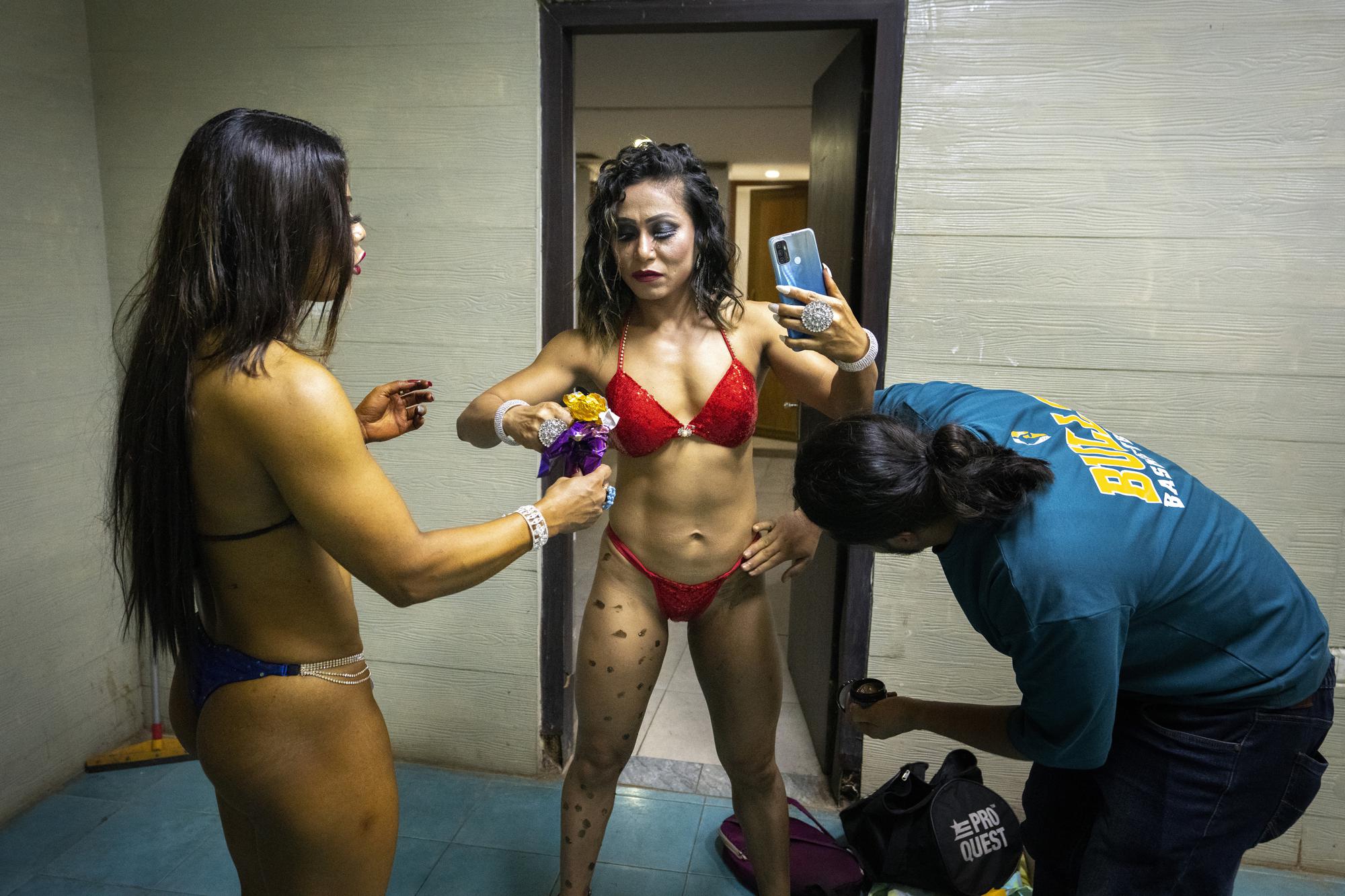 Las fisicoculturistas se preparan entre bastidores para participar en el primer campeonato nacional de fisicoculturismo Miss Saraighat en Gauhati, estado nororiental de Assam, India, el sábado 2 de abril de 2022. (Foto AP/Anupam Nath)